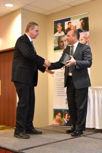 NMCC President Tim Crowley accepts the Catholic Charities Maine RICHES award from CEO Steve Letourneau during the agency’s 50th anniversary event in South Portland.