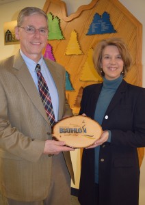 Northern Maine Community College President Tim Crowley accepts a handmade plaque from Biathlon World Cup event director Jane Towle in recognition  for the service and contributions provided by the College for the world-class competition.  