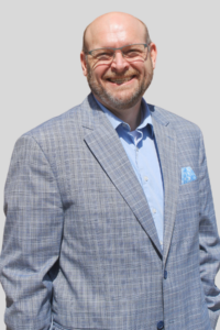 Image of College President in a blue suit, Doug Binsfeld